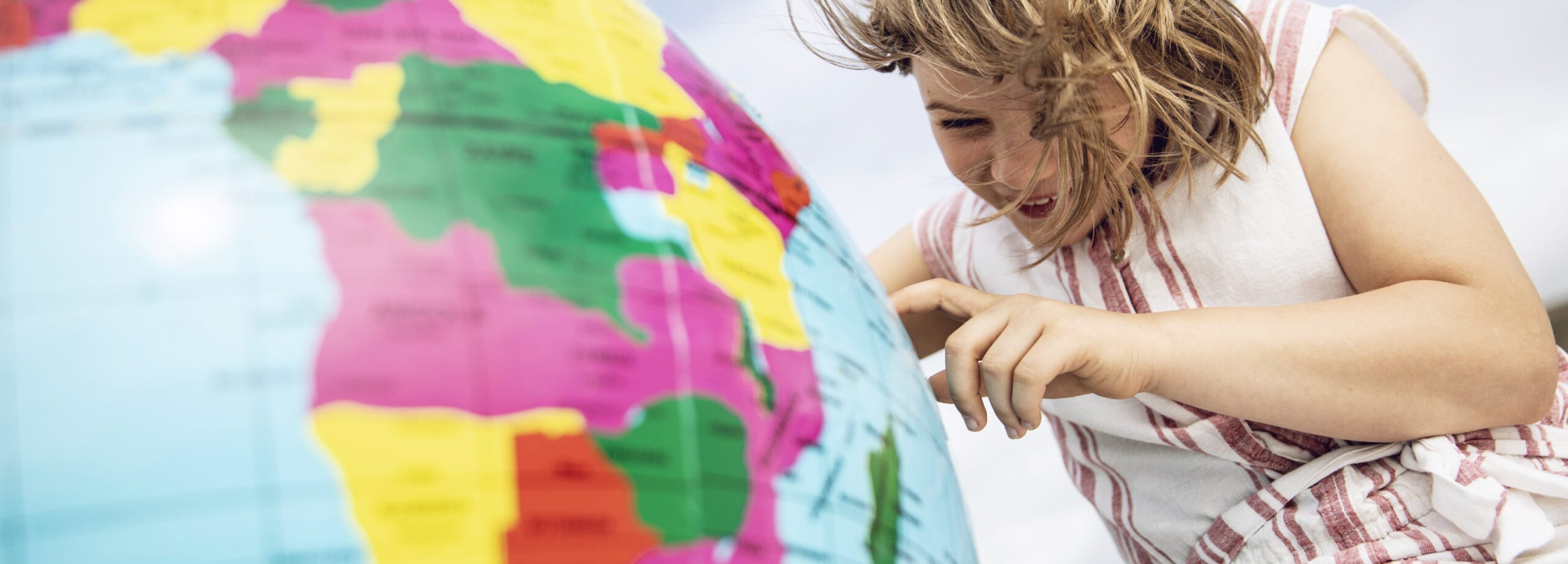 Little girl pointing on inflatable globe